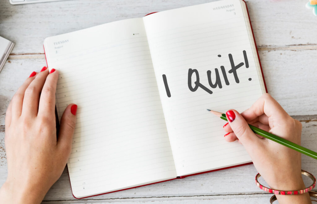 I Quit - woman writing I quit in notebook